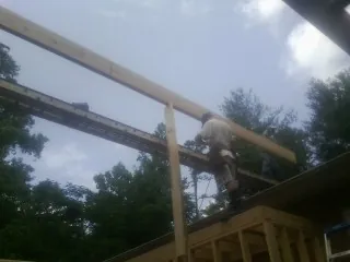 Carpenter setting a ridge beam over a new addition frame — Ice Dam Removal by Roofing Brothers in Olyphant