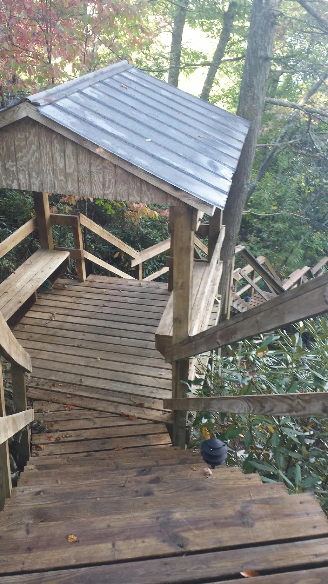 Metal roofed shelter over wooden steps on a wooded walkway — Skylight Repair & Installation work by our crew in Olyphant