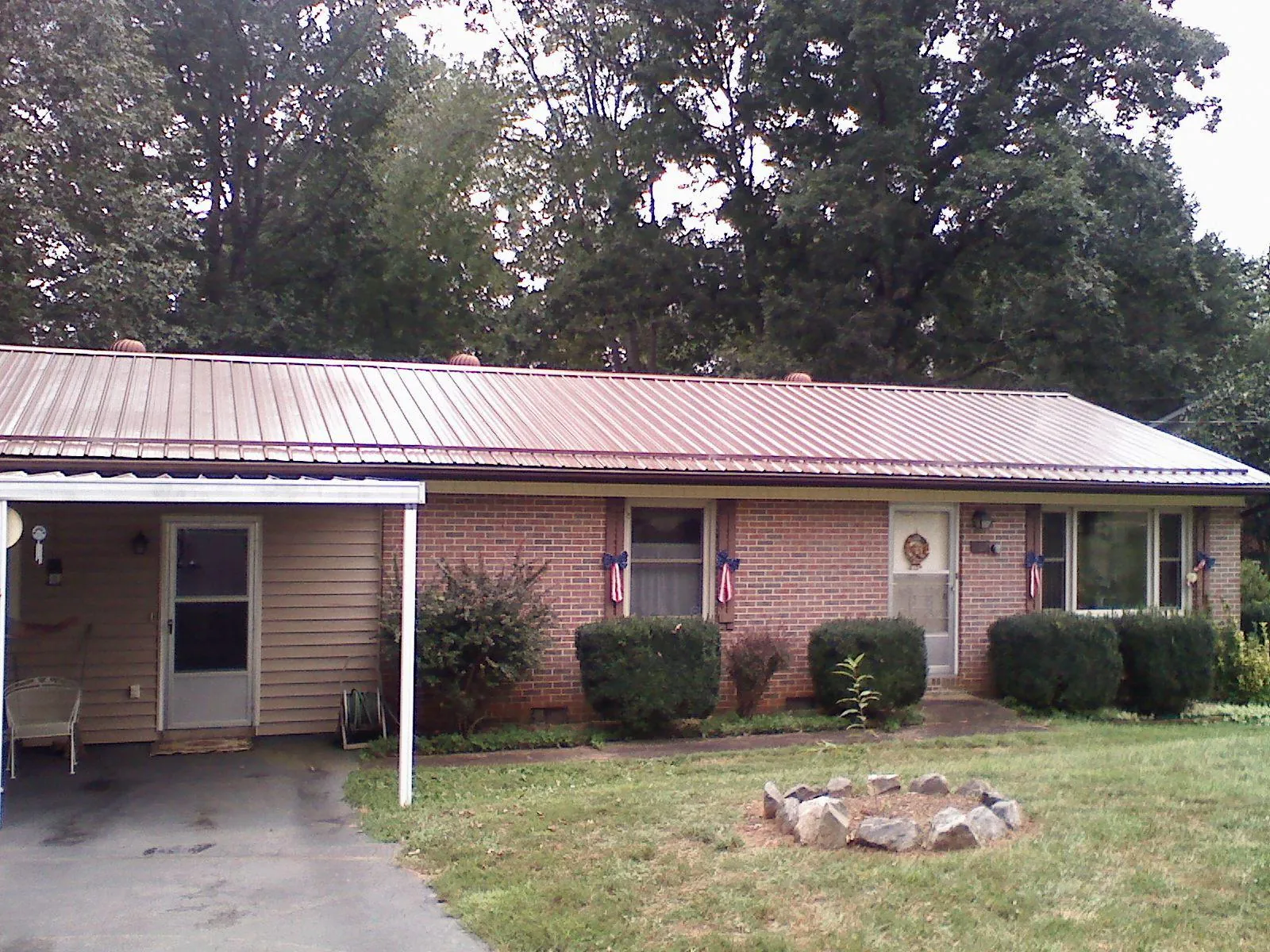 Bronze metal roof and carport on a brick ranch home — Roof Repair work by our crew in Olyphant